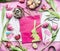 Easter workspace in pink color: tulips flowers and accessories for easter decorations making with eggs, paper bags and basket, to