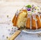 Easter yeast cake Babka covered with icing and decorated with edible flowers on a white plate