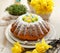 Easter yeast cake sprinkled with powdered sugar, decorated with marzipan eggs.