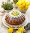 Easter yeast cake sprinkled with powdered sugar, decorated with marzipan eggs.