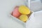 Easter yellow and pink eggs in wooden box on white background. Colorful easter ostrich eggs. Decorative Easter eggs. Large ostrich