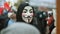 Eastern Europe protesting people mass. Marching anonym in Guy Fawkes mask.