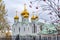 Eastern orthodox crosses on gold domes, cupolas, againts blue sky with clouds.