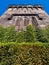 Eastern State Penitentiary tower in Philadelphia, USA, seen from below in perspective with green vegetation and clear blue sky