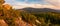 Eastern Sudetes, mountain landscape, view of the Snieznik Massif mountain peaks. The forests are lit by the setting sun