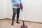 Easy cleaning with a wireless vacuum cleaner. Pregnant woman cleaning floor with handheld vacuum cleaner