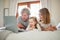 Easy Sunday mornings in our happy home. a little girl bonding with her parents in bed at home.