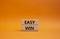 Easy win symbol. Wooden blocks with words Easy win. Beautiful orange background. Business and Easy win concept. Copy space