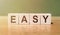 Easy word written on wood cubes with green background