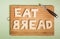 Eat bread text carved out of white bread slices