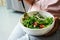 Eat green concept, Young women eating organic fresh vegetable salad in ceramic bowl at home