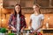 Eat organic for health. Smiling young women cutting vegetables in modern kitchen. Cozy interior.