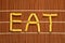 EAT word made with raw pasta elements on bamboo set