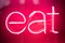 `eat` word pink neon sign lamp on the wall