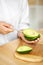 Eating Avocado. Woman Hands Peeling Fresh Avocado With Spoon