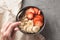 Eating healthy breakfast bowl. Muesli and fresh fruits in ceramic bowl in woman` s hands. Clean eating, dieting, detox, vegetaria