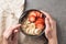 Eating healthy breakfast bowl. Muesli and fresh fruits in ceramic bowl in woman` s hands. Clean eating, dieting, detox, vegetaria