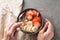 Eating healthy breakfast bowl. Muesli and fresh fruits in ceramic bowl in woman` s hands. Clean eating, dieting, detox, vegetaria