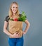 Eating healthy and looking great. Cropped studio shot of a young woman holding a paper bag full of vegetables.