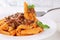 Eating Penne Rigate Bolognese or Bolognaise sauce noodles pasta