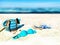 Eautiful beach with white  sand   turquoise ocean water and blue sky women bag and bikini  hat with blue bow accessories  on sand