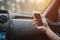 Eautiful woman smiling while sitting on the front passenger seats in the car. Girl is using a smartphone. Hand closeup