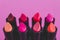 Eauty industry still-life with group of colorful lipsticks lined up on pink background shot from 45 degrees angle with copyspace