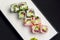 Ebiko black caviar adn red caviar sushi rolls - japanese food style. Served on a white plate over black background