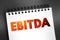 EBITDA - Earnings Before Interest, Taxes, Depreciation and Amortization acronym text on notepad, concept background