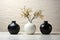 Ebony vases on sleek marble, striking contrast against white wall backdrop