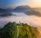 Å ebrelje, Slovenia - Aerial drone view of the beautiful hilltop church of St.Ivan Sv. Ivan Cerkev at sunrise with morning fog