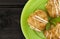 Eclair on green plate, on dark rustic wooden background, top view