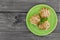 Eclair on green plate, on rustic wooden background, top view.