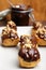 Eclairs with chocolate and nuts on plate on wooden background