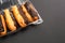 Eclairs with cream filling drenched in chocolate on a black the background