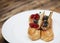 Eclairs decorated with fresh berries on a white plate, handmade, culinary theme, close up