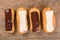 Eclairs different species on wood background isolated.