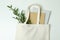 Eco bag with copybooks and twig on white background