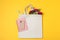 Eco bag, phone, stationery, allium and chrysanthemum on color background