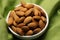Eco conscious snack almonds on canvas napkin, green background perfection