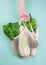 Eco-friendly beige shopping bag with grapes on a white background. String bag with fruits. Zero waste, no plastic concept