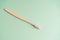 Eco friendly dental health antibacterial bamboo wood toothbrush on green background