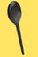 Eco-friendly disposable utensils like spoon on yellow background.