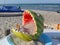 Eco-friendly, funny ashtray for the beach, made from a hollowed out watermelon and filled with sand.