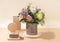 Eco friendly monochrome composition with flowers bouquet and wooden stands with DIY gift box on beige with shadows