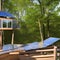 An eco-friendly treehouse with solar panels, rainwater collection system, and natural materials4, Generative AI