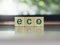 Eco, green words with leaf symbol on wooden cube blocks.