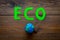 Eco icon cutout near planet Earth plastiline symbol on dark wooden background top view copy space