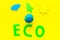 Eco icon cutout near plastiline symbol of planet Earth and environment as sun, trees, clouds on yellow background top