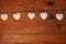 Eco linen fabric hearts on wooden background,Valentines Day concept design.Decorative white heart on jute twine garland